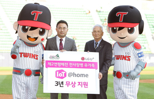 LG유플러스가 제2연평해전 당시 전사한 6명의 장병들 가족에게 홈 IoT 대표 서비스 8종을 3년 간 무상으로 제공한다고 밝혔다. 김규태 LG유플러스 사업협력담당(왼쪽)과 제2연평해전의 참전용사인 고(故) 윤영하 소령의 부친 윤두호씨(오른쪽)가 서울 잠실야구장에서 홈 IoT 무상지원 전달식을 갖고 사진을 촬영하고 있다. <LG유플러스 제공>